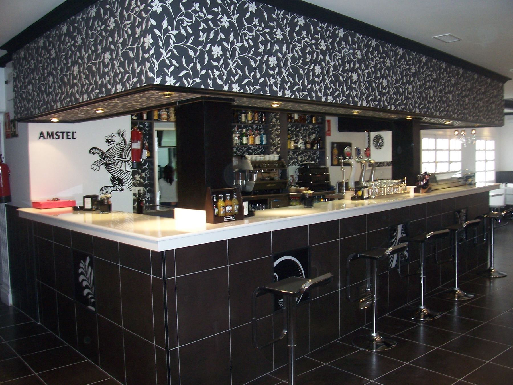 Barra principal de la cafetería con estanterías de bebidas