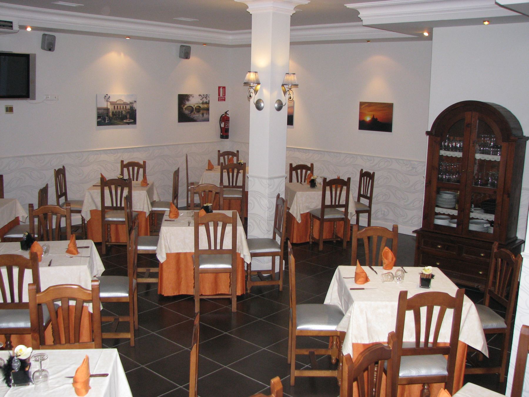 Comedor del restaurante El Rincón de Higuerlop, mesas vestidas de blanco y naranja