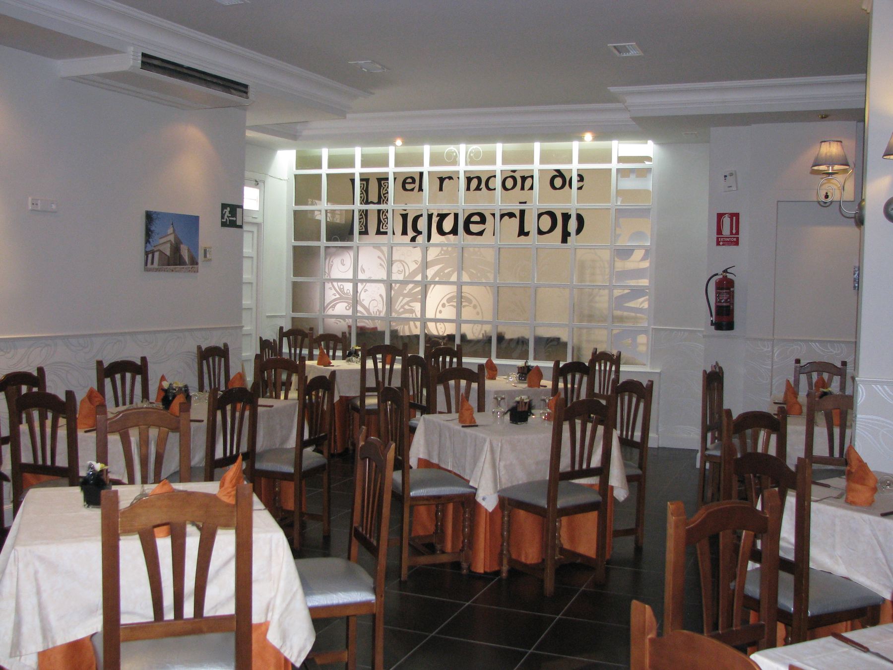 Sala del restaurante con manteles blancos y detalles en naranja